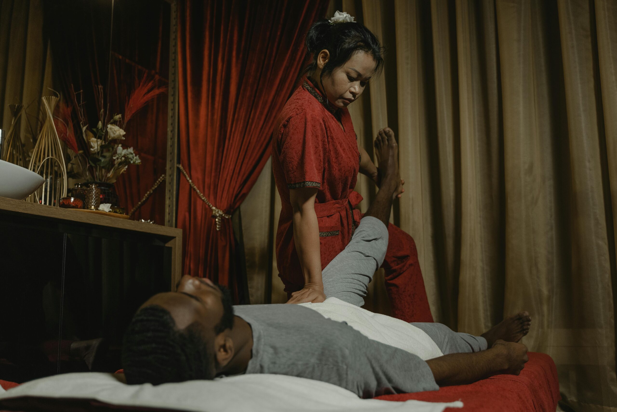Relaxation session with a professional masseur providing therapy for client in a serene salon environment.