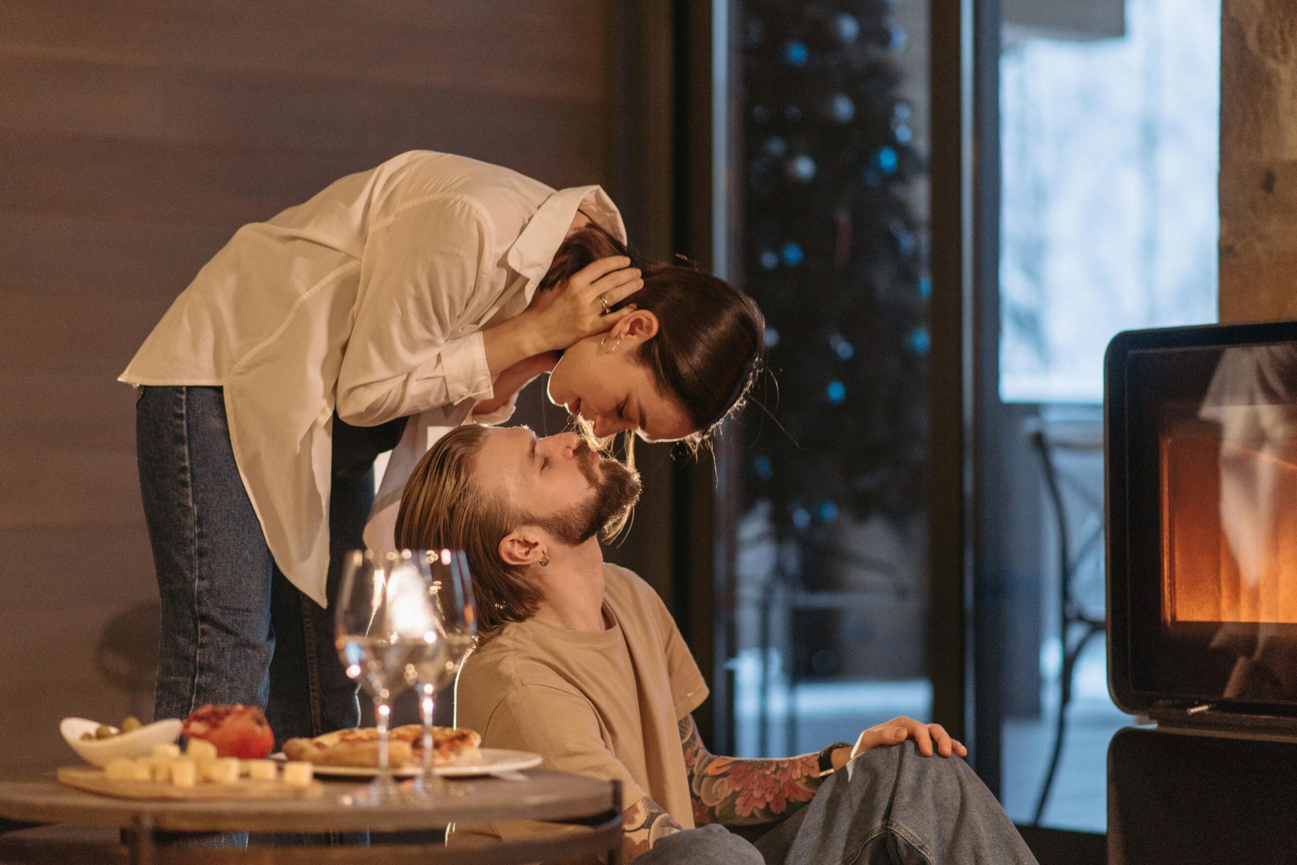 A loving couple shares a cozy moment by the fireplace, surrounded by warmth and romance.